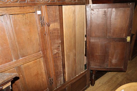 A 17th century oak carved and panelled two door hanging cupboard, W.150cm (a.f.)